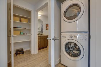 A white washing machine is in a small laundry room.